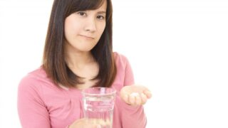 薬を飲む女性